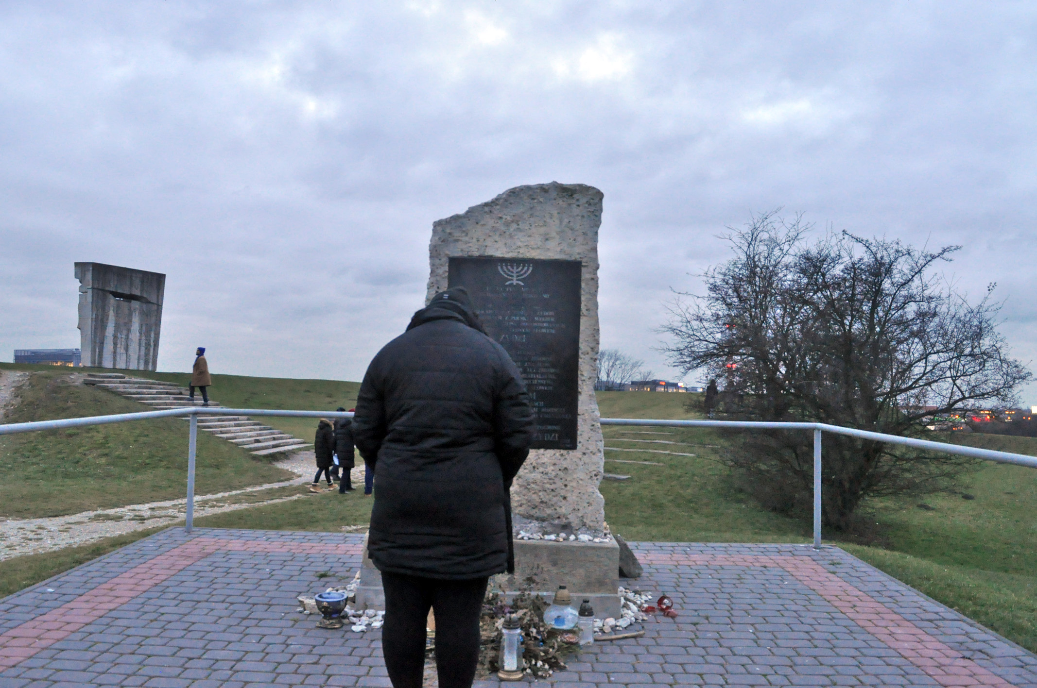 Photograph of Nicole Jones in front of a memorial to the Jews killed at Plaszow Concentration Camp